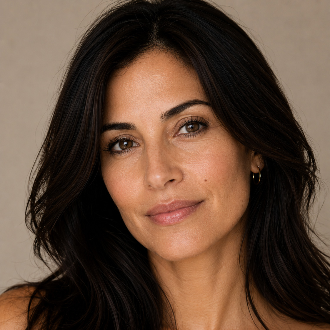 Woman with long dark hair and hoop earrings.